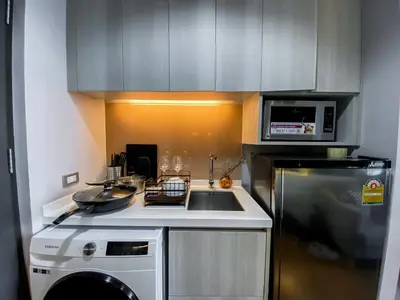a small kitchen with a sink and a microwave at Upscale High-Rise 1BR - Ultra Fast Wifi - Phrom Phong in Bangkok