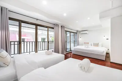 two beds in a room with a balcony at 4BR House For Family&Friends in Bangkok
