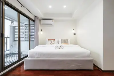 a bedroom with a white bed and a balcony at 4BR House For Family&Friends in Bangkok