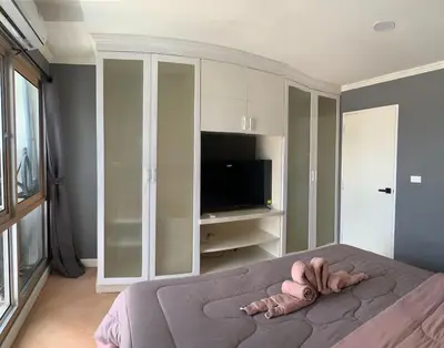 a person laying on a bed in a bedroom at Modern 59m Sukhumvit 1BR - 31st Floor Pool - Gym in Makkasan