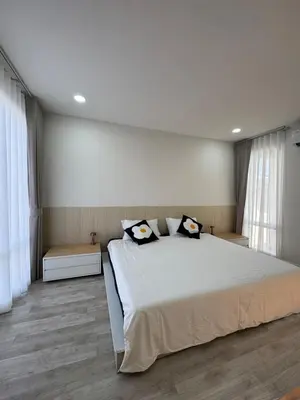 a bedroom with a large bed with two pillows on it at BaanChan House and Studio at Ramkhamhaeng in Ban Bang Toei (1)