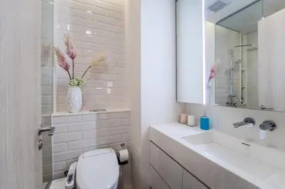 a bathroom with a toilet and a sink and a mirror at 5 Star Centric 1BD Apartment Sukhumvit in Bangkok