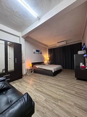 a hotel room with a bed and a couch at Mango Rooms & Rooftop in Bangkok