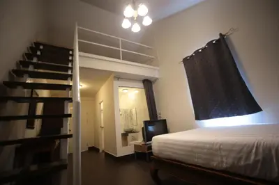 a bedroom with a bed and a spiral staircase at The Myth - Sud Sathorn in Bangkok