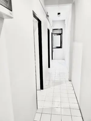 an empty hallway with white walls and black doors at Mitr Inn Khaosan Road - มิตรอินน์ ถนน ข้าวสาร in Bangkok