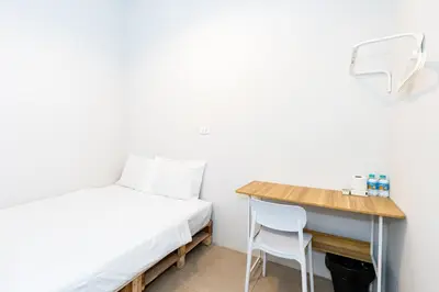 a small room with a bed and a desk at XX The Hidden Khaosan Rambutri - เดอะ ฮิดเดน ข้าวสาร รามบุตรี xPro in Bangkok