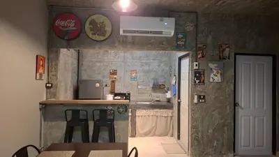 a small kitchen with a counter and tables and chairs at The Loft House Muangthong in Ban Bang Phang