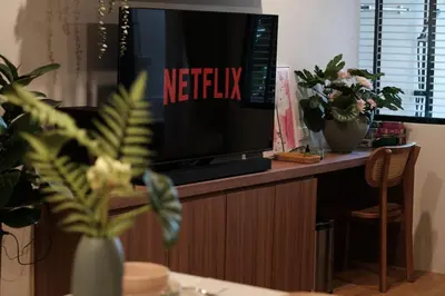 a television sitting on top of a wooden cabinet at The Shantipan Lotus - Cozy 2BR Family Stay 400m from BTS Station in Bangkok