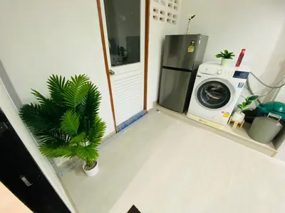 a laundry room with a washer and a washing machine at Cozy Nest Near Downtown in Bangkok