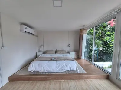 a bedroom with a bed and a large window at Cat House BKK in Bangkok