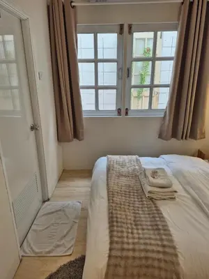 a bedroom with a bed and two windows at Cat House BKK in Bangkok