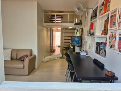 a living room with a table and a couch at Cat House BKK in Bangkok
