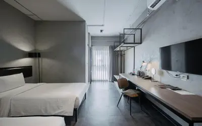 a bedroom with a bed and a desk and a tv at The Ex Capital Hotel Bangkok by Dancenter in Bangkok