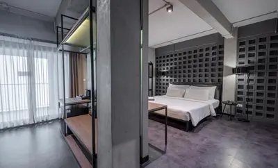 a bedroom with a large white bed and a table at The Ex Capital Hotel Bangkok by Dancenter in Bangkok