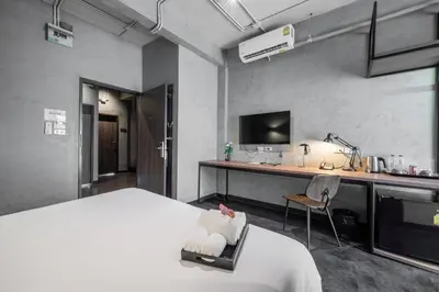 a hotel room with a bed and a desk with a computer at The Ex Capital Hotel Bangkok by Dancenter in Bangkok