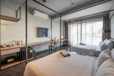 a hotel room with two beds and a tv at The Ex Capital Hotel Bangkok by Dancenter in Bangkok