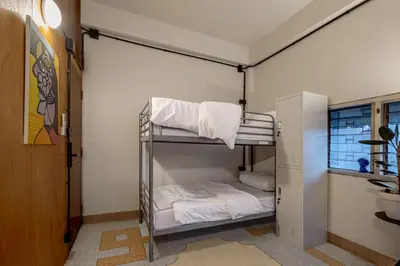 a room with a bunk bed with white sheets at MornSamyan in Bang Rak