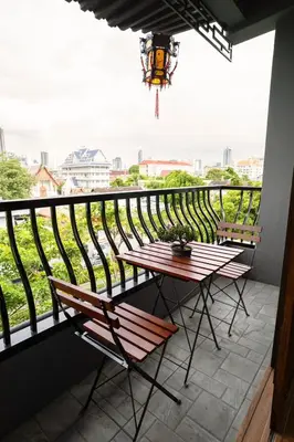 a table and chairs on a balcony with a view at Soultel โซลเทล in Khlong San