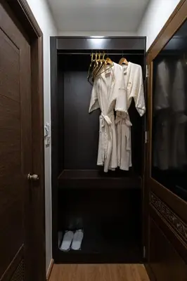 a closet with white coats and shoes in it at Soultel โซลเทล in Khlong San