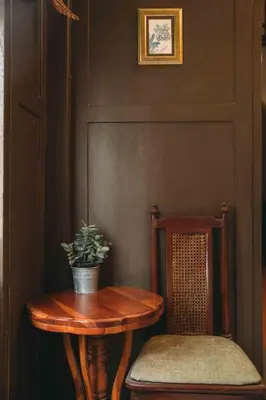 a wooden table and a chair with a potted plant at Casa Acero in Bangkok