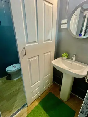 a bathroom with a white sink and a mirror at Sheikh Stay In Hostel in Bangkok