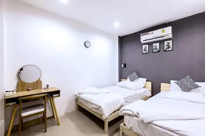 two beds in a room with a desk and a mirror at Sheikh Stay In Hostel in Bangkok