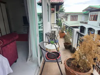 a balcony with chairs and a couch on a balcony at Sheikh Stay In Hostel in Bangkok