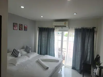 a bedroom with a white bed and a sliding glass door at Sheikh Stay In Hostel in Bangkok