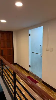 a large glass door in a room with a staircase at Rewadee House in Nonthaburi