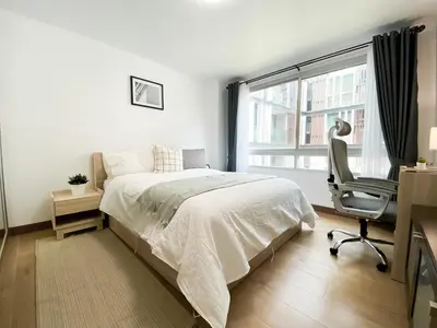 a bedroom with a bed and a desk and a chair at Spacious 53 Sqm l BTS Thong Lo l Ultra Fast WiFi in Bangkok