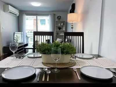 a dining room table with white plates and silverware at Spacious 53 Sqm l BTS Thong Lo l Ultra Fast WiFi in Bangkok
