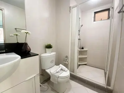 a white bathroom with a toilet and a shower at Spacious 53 Sqm l BTS Thong Lo l Ultra Fast WiFi in Bangkok