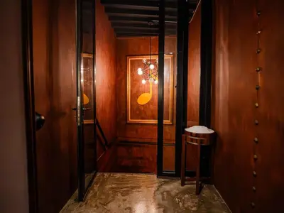 a hallway with wooden walls and a door with a chandelier at Boutique Suite 3BR x The Lobby Bar & Bed in Bang Kapi