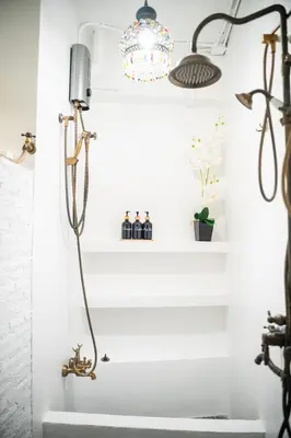 a bathroom with white walls and a light fixture at Boutique Suite 3BR x The Lobby Bar & Bed in Bang Kapi