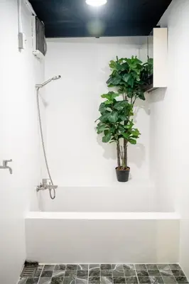a bathroom with a plant in a bath tub at Boutique Suite 3BR x The Lobby Bar & Bed in Bang Kapi
