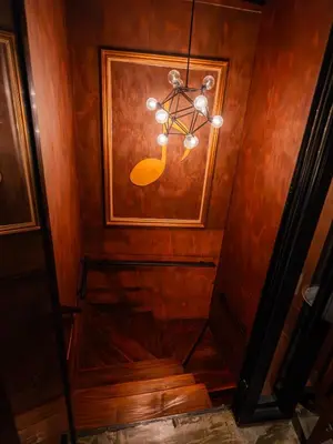 a stairway with a chandelier and a wooden wall at Boutique Suite 3BR x The Lobby Bar & Bed in Bang Kapi