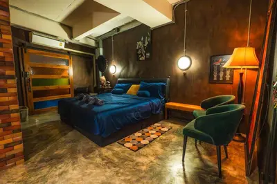 a bedroom with a bed and a chair at Boutique Suite 3BR x The Lobby Bar & Bed in Bang Kapi