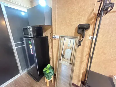 a small room with a refrigerator and a plant in it at Secret Retro Vintage Building ห้องลับเรโทรในตึกวินเทจ in Ban Song Hong