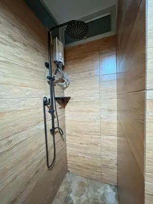 a shower in a bathroom with a wooden wall at Secret Retro Vintage Building ห้องลับเรโทรในตึกวินเทจ in Ban Song Hong