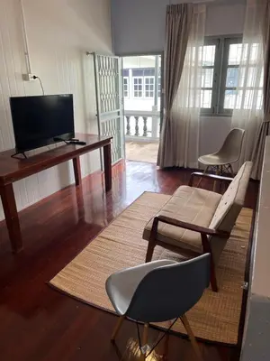 a living room with a television and a table and chairs at Saen Saran property in Sathani Bang Ramat