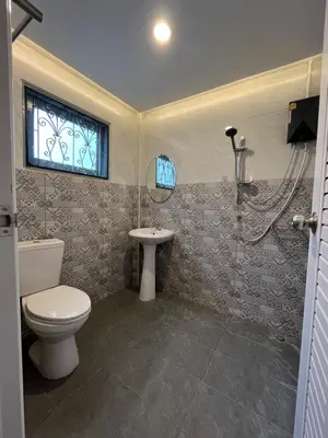 a bathroom with a toilet and a sink and a shower at Saen Saran property in Sathani Bang Ramat
