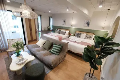 a large room with two beds and a couch at The Shantipan Jasmine - Cozy City Retreat 400m from BTS Station in Bangkok