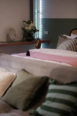a bedroom with a bed with a pink blanket at The Shantipan Jasmine - Cozy City Retreat 400m from BTS Station in Bangkok