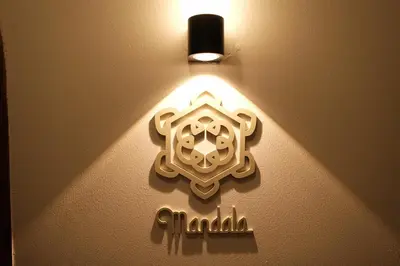 a light on a wall with a sign on it at The Shantipan Mandala - Cozy City Retreat 400m from BTS Station in Bangkok