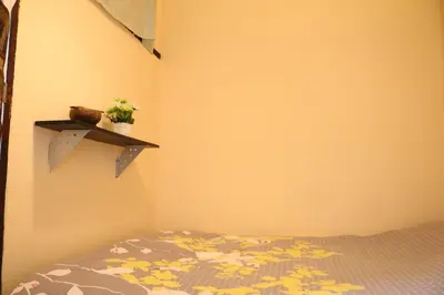 a bedroom with a bed and a shelf on the wall at Eco House in Bangkok