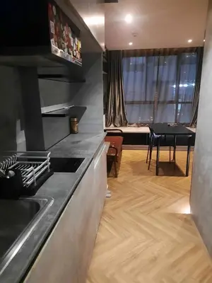 a kitchen with a sink and a table in a room at Spaceous Appartment on Sukhumvit in Bangkok