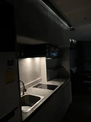 a kitchen with a sink in a dark room at Spaceous Appartment on Sukhumvit in Bangkok