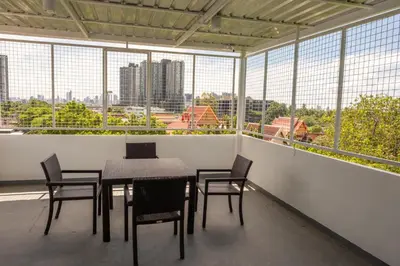 a dining room with a table and chairs and windows at Kanal Bangkok Service Residence in Ban Khlong Bang Chak