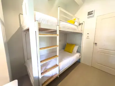 a bunk bed in a small room with a white bunk bed at Kanal Bangkok Service Residence in Ban Khlong Bang Chak