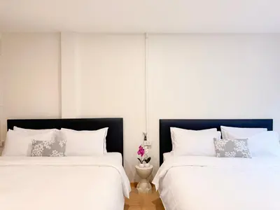 two beds sitting next to each other in a bedroom at \u8c6a\u534e\u5e02\u4e2d\u5fc3\u8054\u6392\u522b\u5885-\u66b9\u7f57\u767e\u4e3d\u5bab-siam in Pratunam